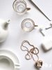 gold colored heart pendant necklace beside two glass mugs on 860009 scaled
